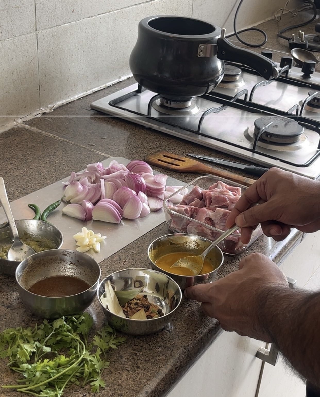 Sunday prep — onions, whole spices, and the mutton before the handi goes on